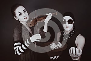 Two mimes playing a violin for the money
