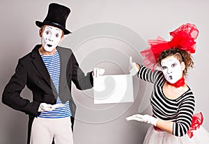 Two mimes with a sign for advertising, April Fools Day concept