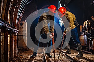 Two miners in the mine. Copy space. Hard work in a coal mine. Tired workers in a coal mine