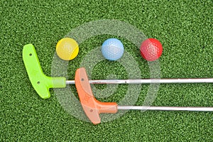 Two Mini Golf Putters and Three Balls
