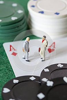 Two miniature businessman standing on two aces