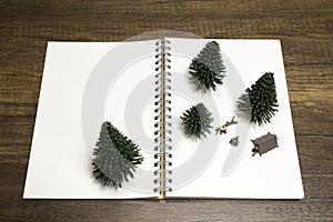 Two miniature camping with pine tree on white blank notebook