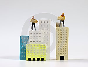 Two miniature couriers standing on top of miniature buildings.