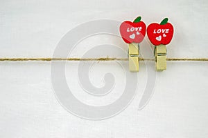 Two miniature, wooden, apple-shaped pegs.