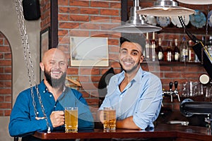 Two Mix Race Man In Bar Hold Glasses Sit At Counter, Drinking Beer, Cheerful Friends Meeting