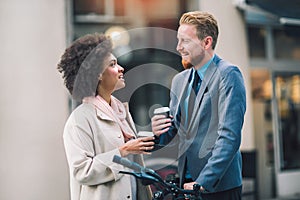 Two mixed race business people talking outside company