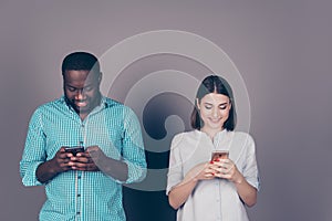 Two mixed race people look at phone. Beautiful caucasian girl and handsome afro american guy type sms