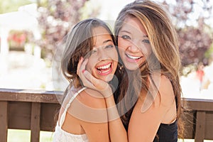 Two Mixed Race Teen Girlfriends Hug for Portrait Outdoors