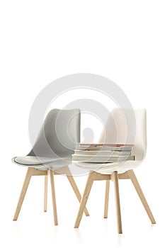 Two modern chairs with a pile of books