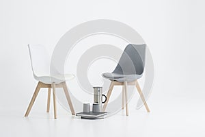 Two modern chairs with a serving of coffee