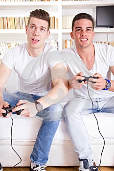 Two modern guys playing computer game holding controllers