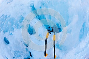 Two modern ice tools planted in the icefall during a pitch.