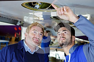 two modern mechanics working in hangar