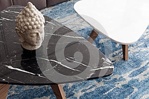 Two modern stool made of black and white artificial stone stands on a carpet with fine nap, a top view.
