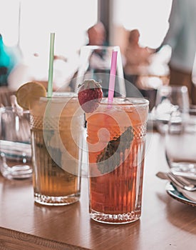 Two mojito cocktails made with aged rum, mint, and different fruits.