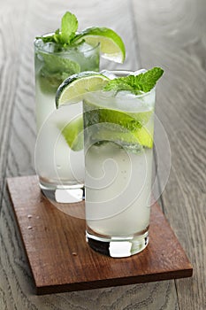 Two mojito cocktails on old oak table