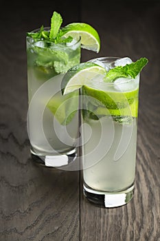 Two mojito cocktails on old oak table