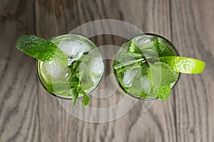 Two mojito cocktails on old oak table