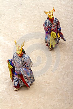 Two monks in deer mask perform a religious masked and costumed mystery dance of Tibetan Buddhism on the Cham Dance Festival