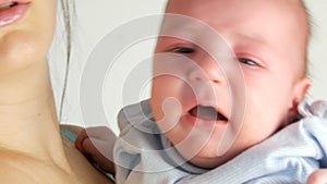 Two month old newborn baby cries loudly. Child face close up view