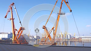 Two moored floating cranes stand in the port in anticipation of a tugboat. 4K.