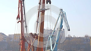 Two moored floating cranes stand in the port in anticipation of a tugboat. 4K.