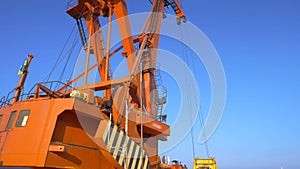 Two moored floating cranes stand in the port in anticipation of a tugboat. 4K.