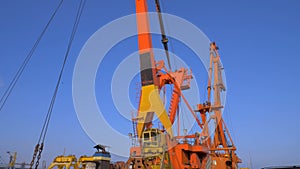 Two moored floating cranes stand in the port in anticipation of a tugboat. 4K.