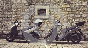 Two Mopeds in front of the Wall