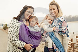 Two mothers with babies in baby carriers warp
