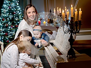 Two mothers with children in the New Year at a white grand piano