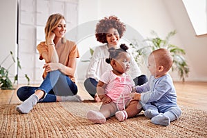 Two Mothers Meeting For Play Date With Babies At Home In Loft Apartment