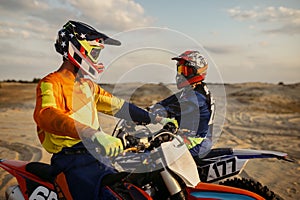 Two motocross MX riders talking before racing photo