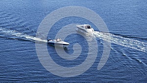 Two motor boats traveling close together at sea