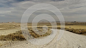 Two motorbikes riding off into the distance on a secondary dirt road