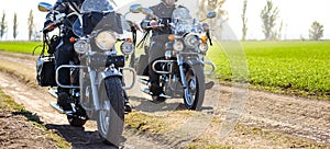 Two Motorcycle Drivers Riding Custom Chopper Bikes on an Autumn Dirt Road in the Green Field. Adventure Concept.