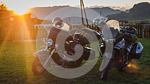 Two motorcycles on a sunset background. Altai mountains. Two different types of motorcycle in one trip.