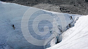 Two mountain guide candidates training ice axe and rope skills on a glacier in the Swiss Alps