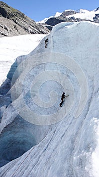 Two mountain guide candidates training ice axe and rope skills on a glacier in the Swiss Alps