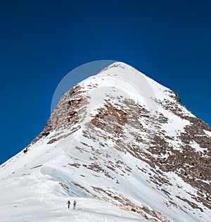 two mountaineers climb a large snow-capped peak called Arlas in the Spanish Pyrenees