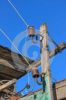 Two mounted on old wooden plank old-fashioned out-of-date ceramic insulators for a hand-made electric line