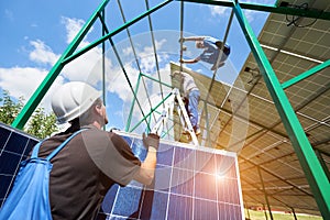 Two mounters installing solar batteries on metallic construction.
