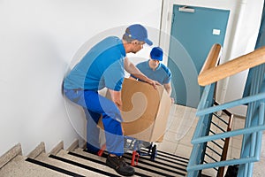 Two Movers With Box On Staircase