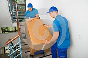 Two Movers With Box On Staircase