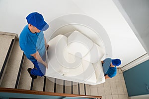 Two Movers Carrying Sofa On Staircase photo