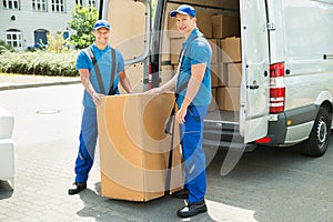 Two Movers Loading Boxes In Truck