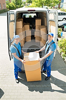 Two Movers Loading Boxes In Truck