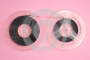 Two movie film reels isolated on pink background top view