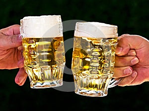 Two mugs of beer with us beer foam