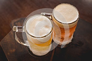 two mugs of chopp on the table.